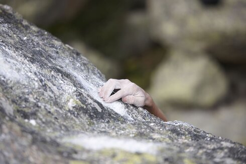 Die Hände des Kletterers sind am Ende des Boulderproblems angekommen. 