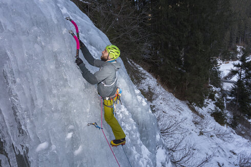 Ein Eiskletterer klettert einen Eisfall empor