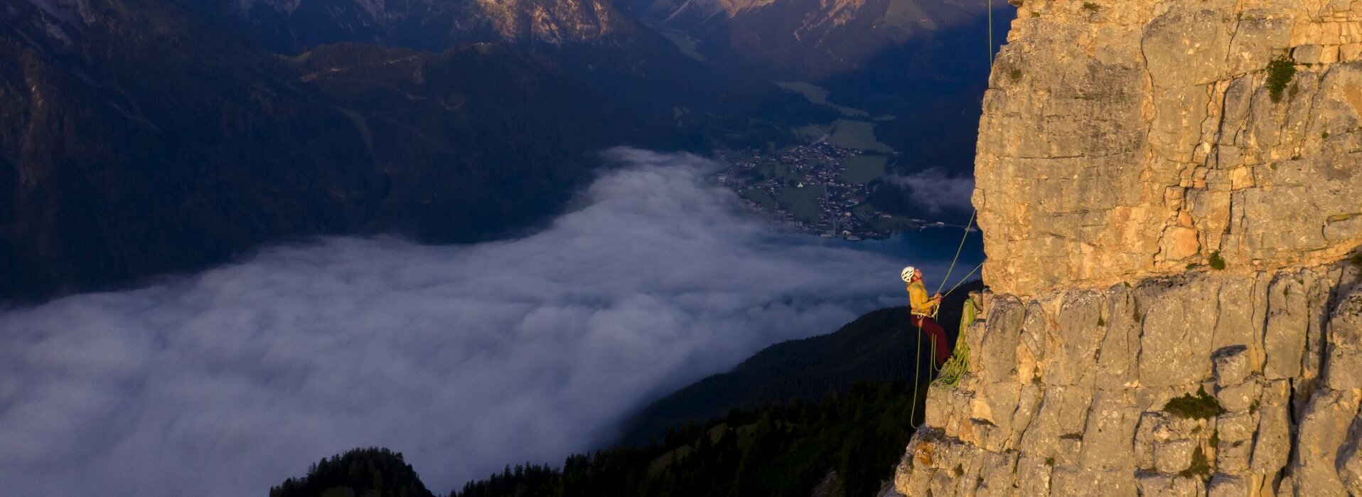 Zwei Personen klettern auf einem großen Berg.