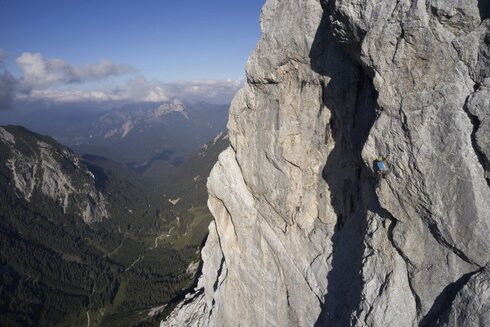 Ein Mann klettert auf einem hohen Berg.