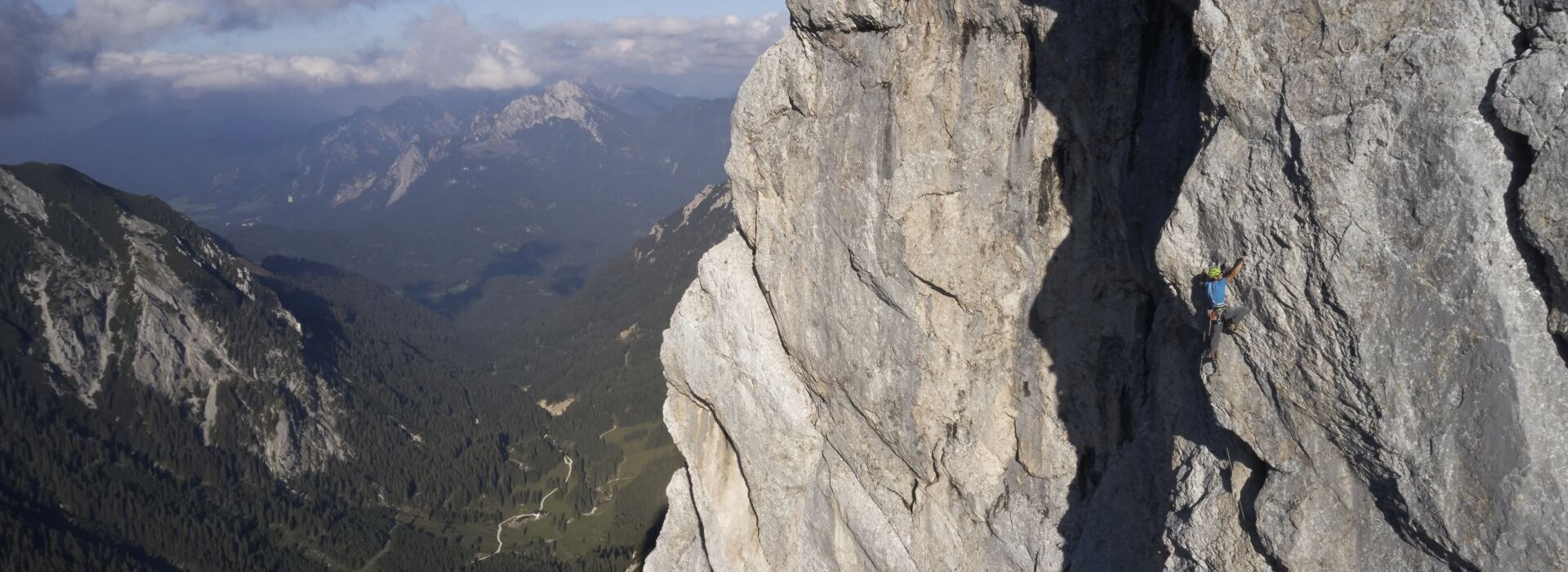 Ein Mann klettert auf einem hohen Berg.