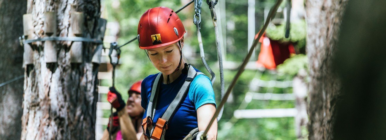 Eine Frau klettert in einem Kletterpark.