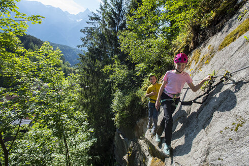 Zwei Kinder gehen gesichert einen einfachen Klettersteig im Ötztal