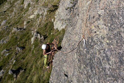 Frau klettert an einen Berg.