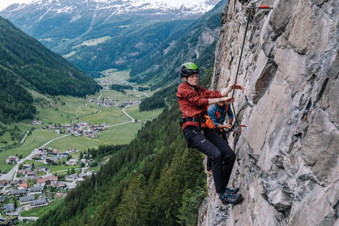 Eine Frau klettert auf einem Berg.