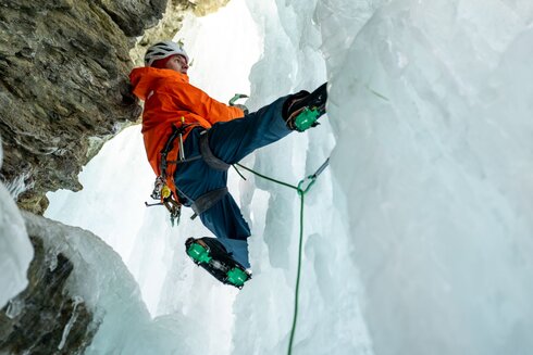 Ein Mann klettert auf einer Eiswand.