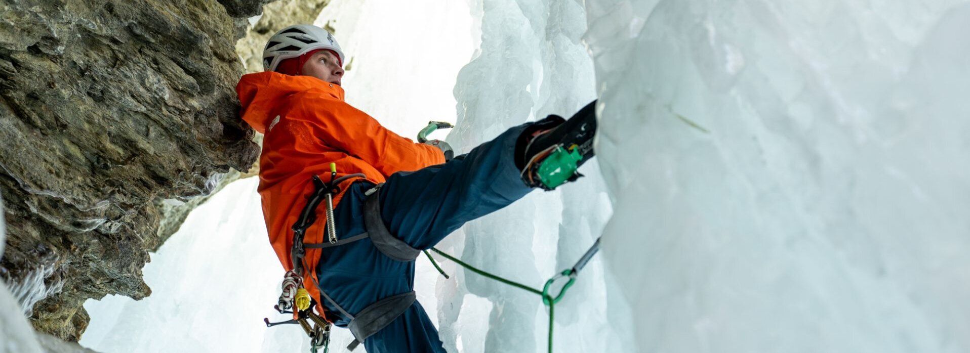 Ein Mann klettert auf einer Eiswand.