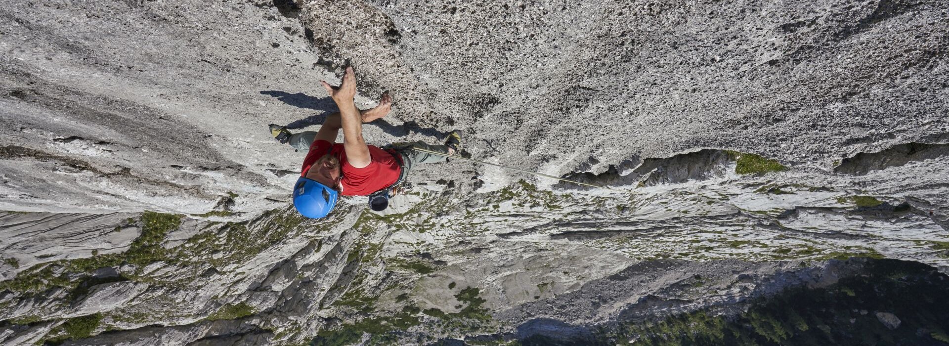 Ein Mann klettert auf einem hohen Berg.