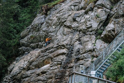 Eine Person klettert einen Felsen hoch.