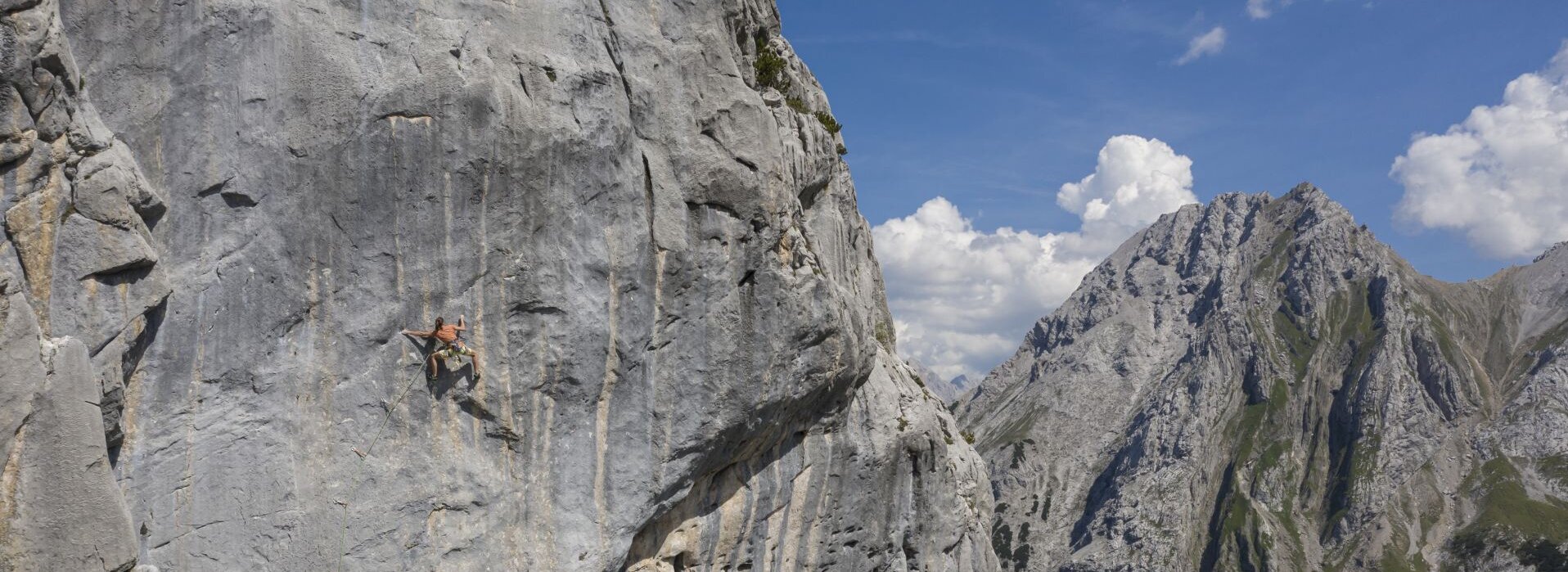 Eine Person klettert auf einem hohen Berg.