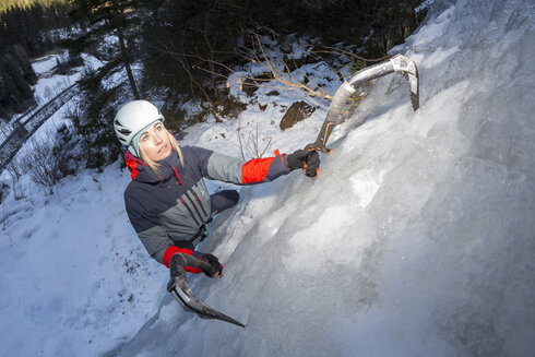 Eine Frau hat die Situation beim Eisklettern im Griff