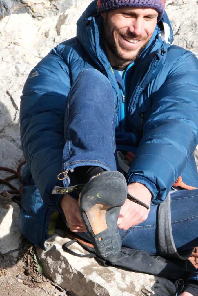 Im Winter wärmt man die Kletterschuhe vor dem Anziehen am besten unter der Daunenjacke, Foto: Simon Schöpf I Climbers Paradise