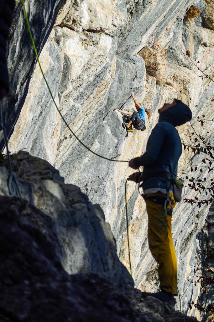 Winterklettern: Der Sicherer ist gut eingepackt, der Kletterer klettert im T-Shirt, Foto: Simon Schöpf I Climbers Paradise