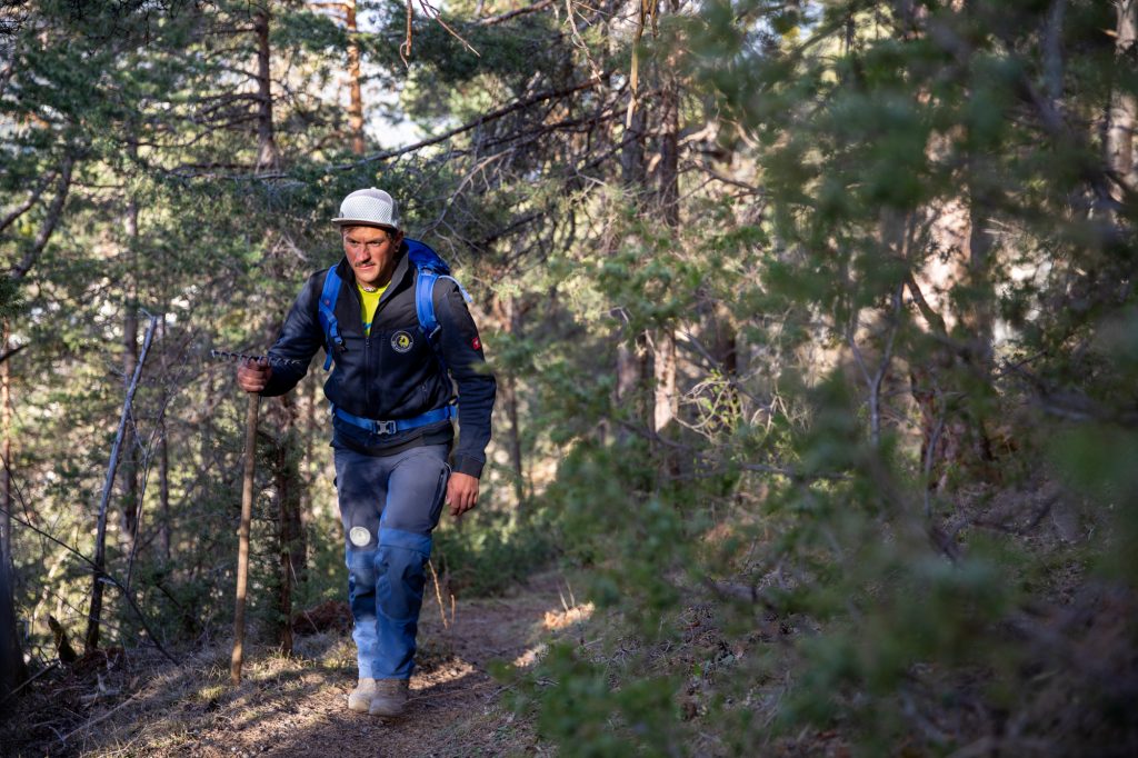 Das Bild zeigt einen Arbeiter am Weg zum Kletterfelsen für Wartungsarbeiten.